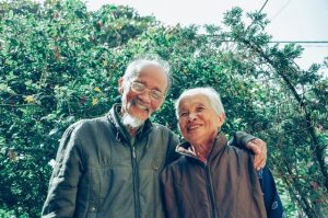 smiling elderly couple in garden